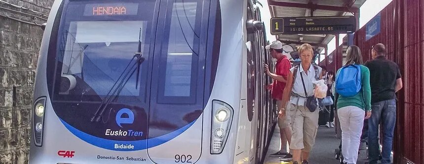 Tren Topo de Euskotren llegando a la estación de Hendaia, con viajeros subiendo al andén